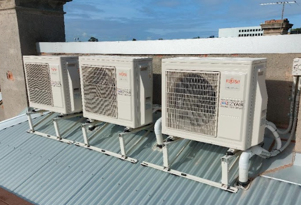 Three reverse cycle outdoor units on a rooftop frame, used to explain defrost mode